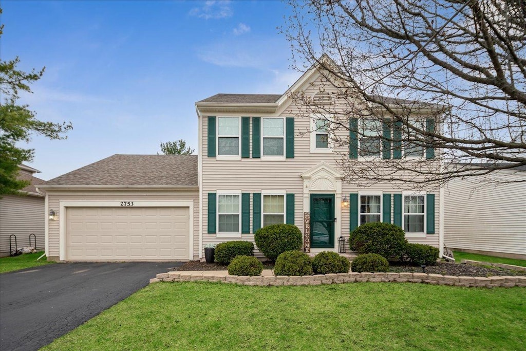 2753 Lansdale St, Aurora, IL 60503 - colonial inspired home featuring an attached garage, a front lawn, and aphalt driveway