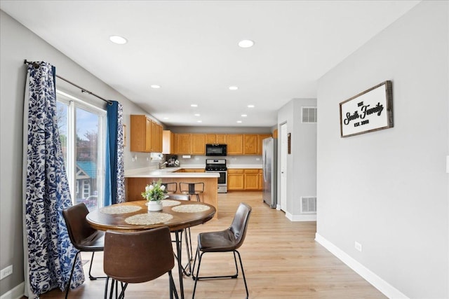 dining space with baseboards, light wood-type flooring, recessed lighting, and visible vents