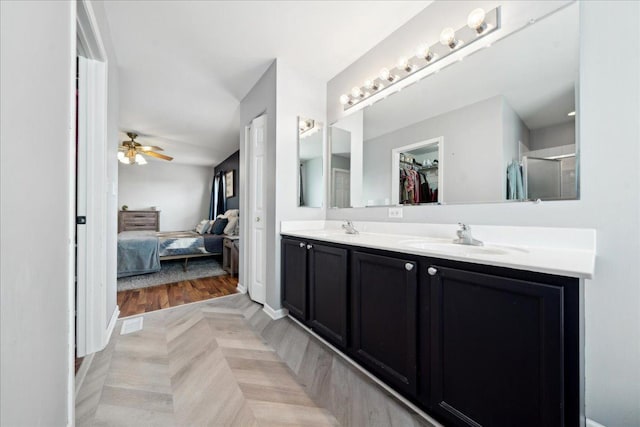 ensuite bathroom featuring a sink, ensuite bathroom, a ceiling fan, and double vanity
