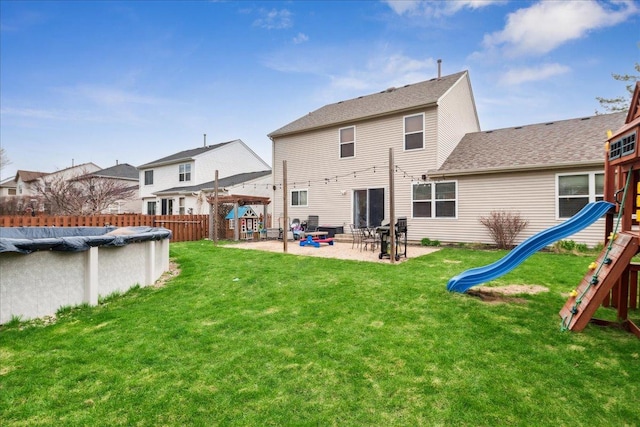 back of property featuring a fenced in pool, a fenced backyard, a playground, a patio, and a lawn