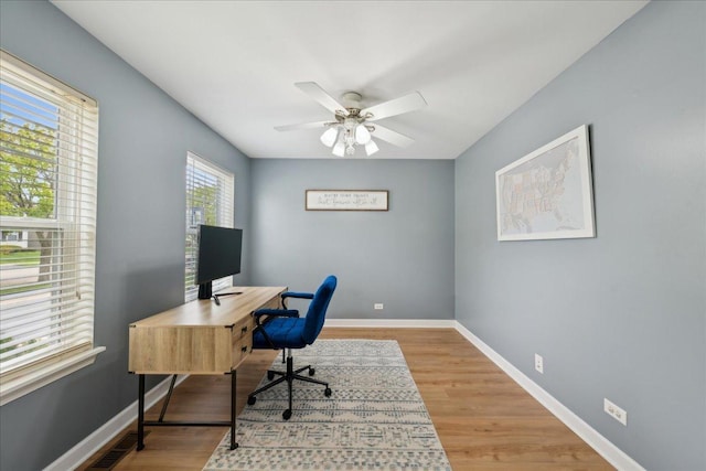 home office featuring baseboards, a ceiling fan, and wood finished floors