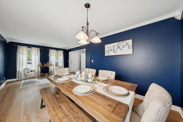dining room with baseboards, ornamental molding, and wood finished floors