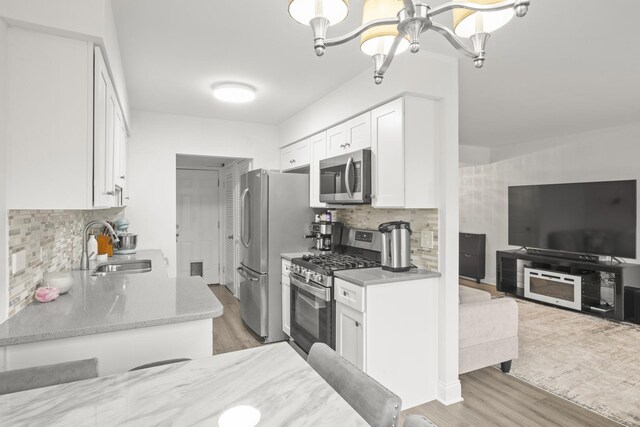 277 E Alpine Dr, Glendale Heights, IL 60139 - kitchen featuring white cabinets, appliances with stainless steel finishes, a sink, light wood finished floors, and backsplash