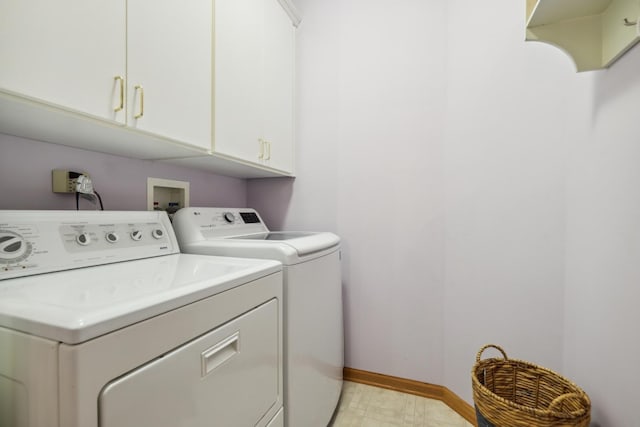 washroom with washing machine and dryer, baseboards, light floors, and cabinet space