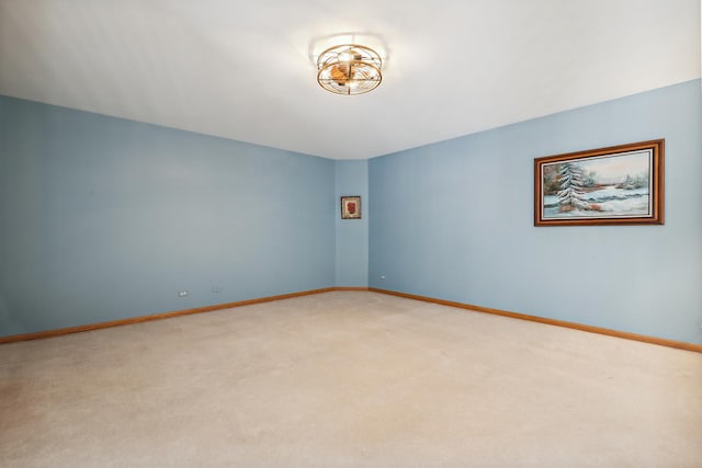 unfurnished room with baseboards and light colored carpet