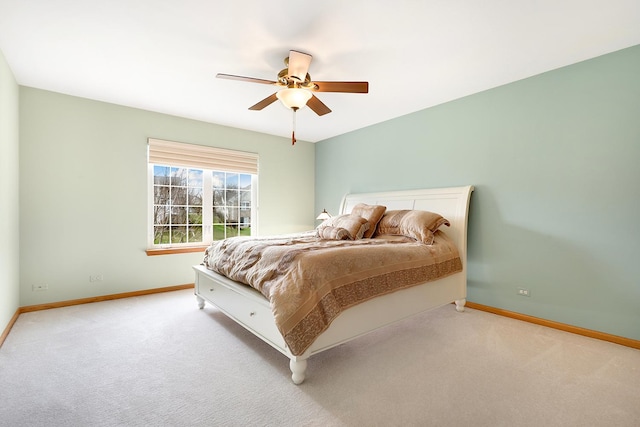 bedroom with baseboards, a ceiling fan, and light carpet