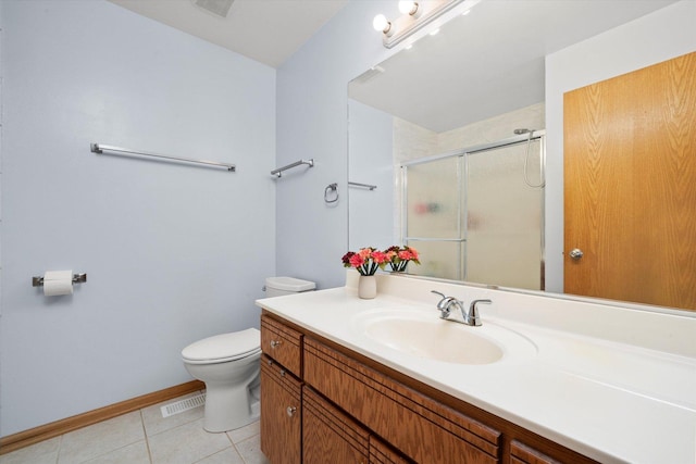 bathroom with a stall shower, toilet, vanity, tile patterned floors, and baseboards