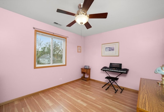 living area with light wood finished floors, baseboards, and ceiling fan