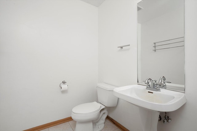 bathroom with toilet, baseboards, and tile patterned floors