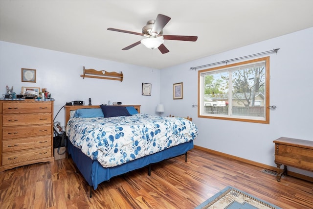 bedroom featuring wood finished floors, baseboards, and ceiling fan