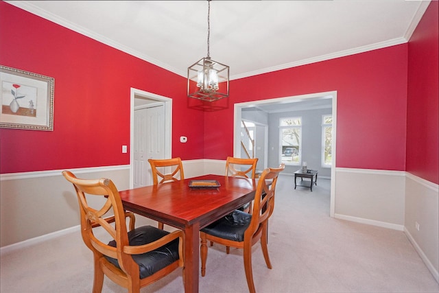 dining area with ornamental molding, baseboards, an inviting chandelier, and light carpet
