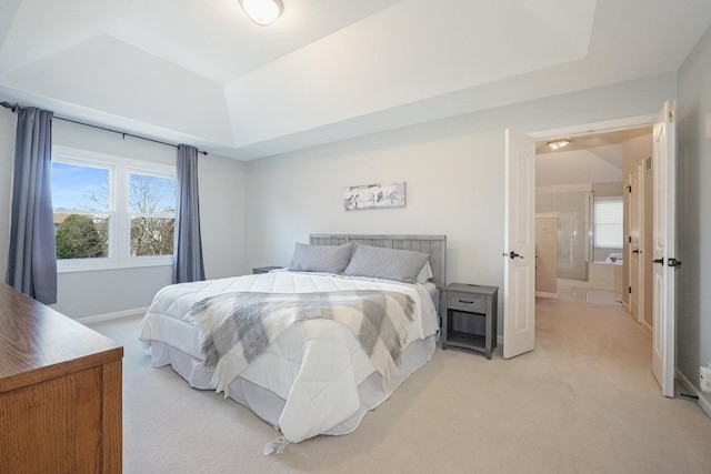 bedroom with a tray ceiling, baseboards, multiple windows, and light carpet