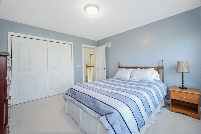 bedroom with light carpet, visible vents, and a closet