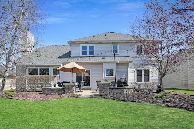rear view of house featuring a yard, roof with shingles, a patio area, and a chimney