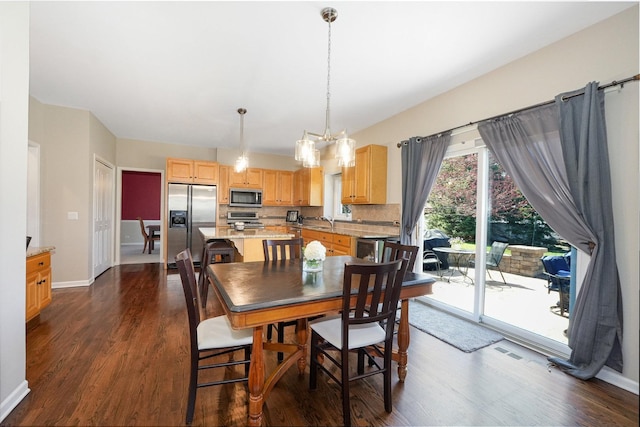 dining room with a chandelier, baseboards, and dark wood-style floors