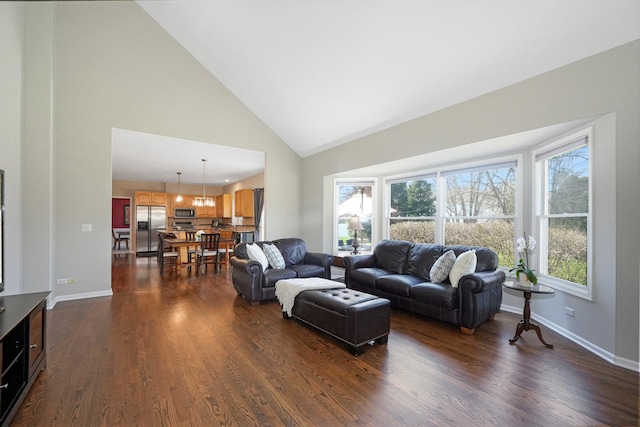 living area featuring dark wood-type flooring, high vaulted ceiling, and baseboards