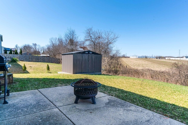 view of patio featuring a shed, an outdoor structure, fence, and an outdoor fire pit