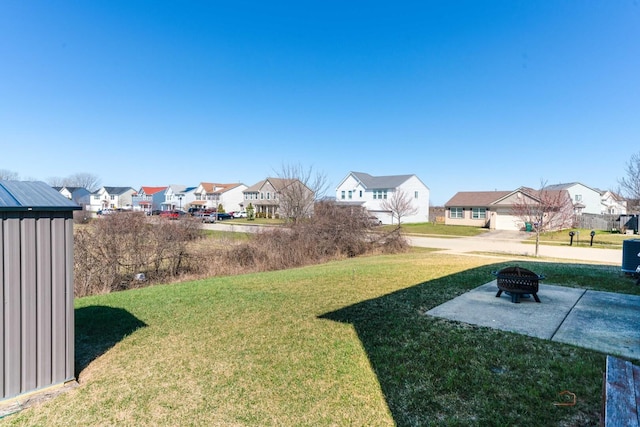 view of yard with a fire pit and a residential view