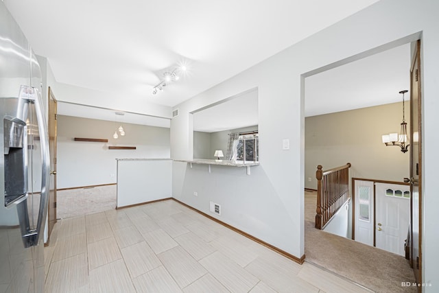 kitchen featuring stainless steel refrigerator with ice dispenser, visible vents, baseboards, and an inviting chandelier