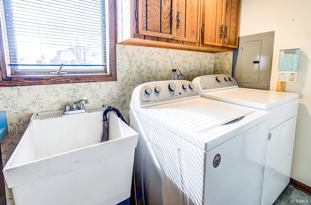washroom featuring electric panel, a sink, wallpapered walls, cabinet space, and washing machine and dryer