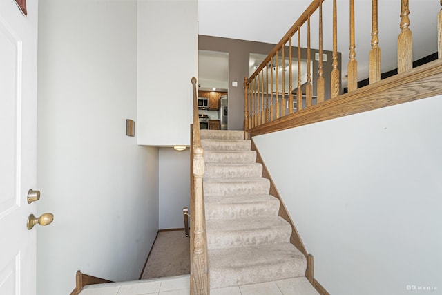 staircase with tile patterned floors and baseboards