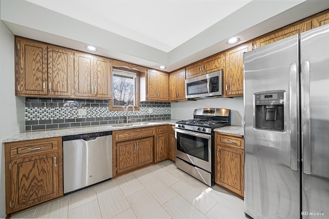 kitchen featuring a sink, brown cabinets, recessed lighting, stainless steel appliances, and decorative backsplash