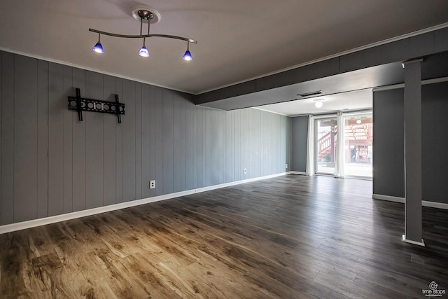 interior space with visible vents, baseboards, ornamental molding, and wood finished floors
