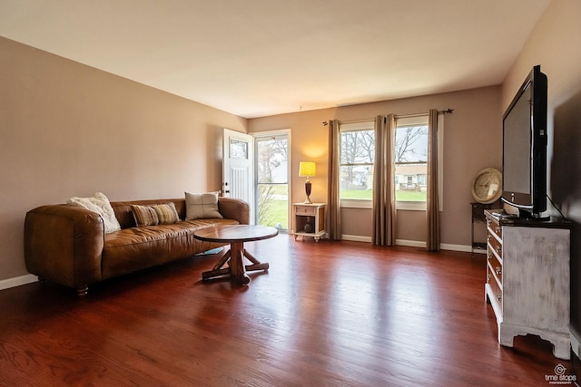 living area featuring dark wood-type flooring and baseboards