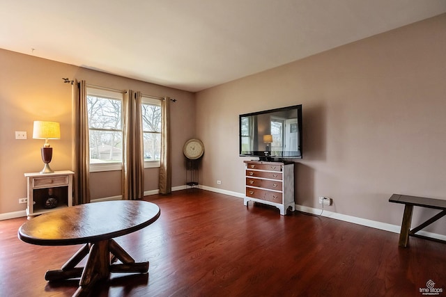 living area with baseboards and wood finished floors