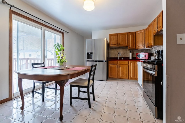 kitchen featuring brown cabinets, tasteful backsplash, a sink, and stainless steel appliances