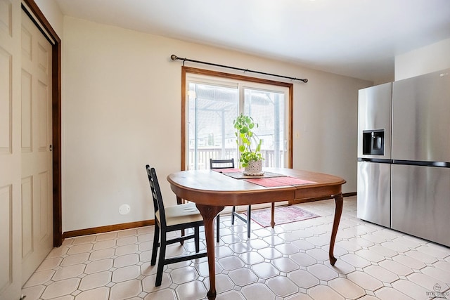 dining space with baseboards and light floors