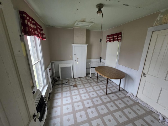 dining area featuring a wainscoted wall and light floors