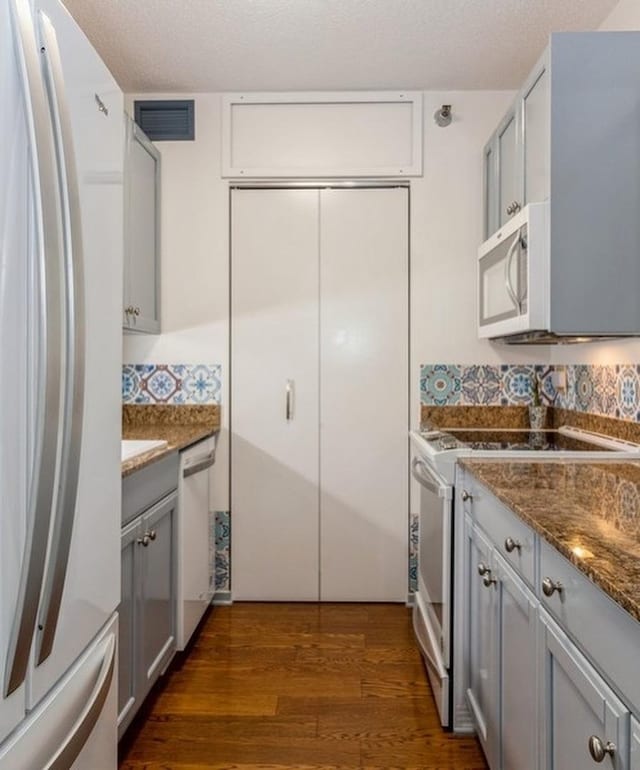400 N Lasalle Dr Unit 3706, Chicago, IL 60654 - kitchen with dark wood finished floors, white appliances, visible vents, decorative backsplash, and gray cabinetry
