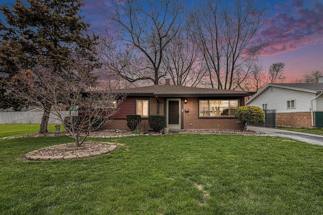 305 166th St, Calumet City, IL 60409 - view of front facade with a chimney, brick siding, fence, and a lawn