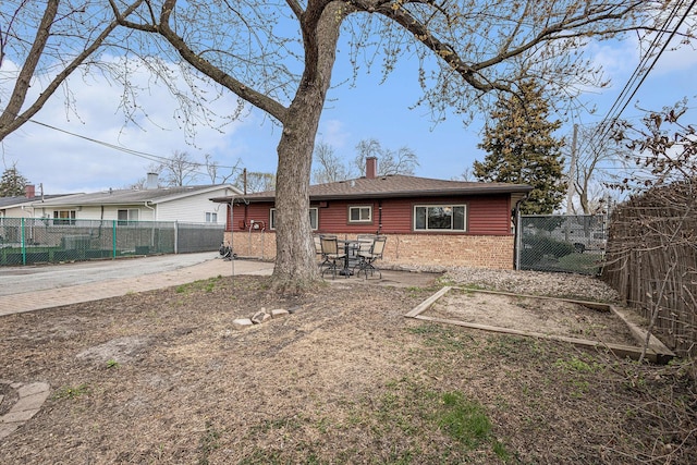 305 166th St, Calumet City, IL 60409 - back of property featuring fence, a chimney, brick siding, and a patio