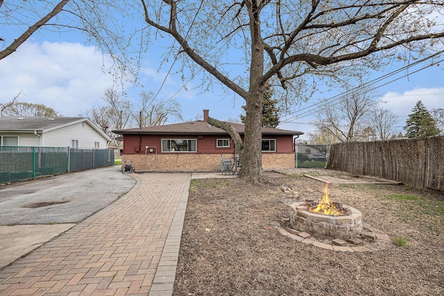 305 166th St, Calumet City, IL 60409 - rear view of house featuring a fire pit, fence, a chimney, and driveway