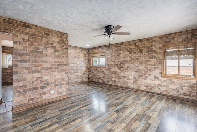 305 166th St, Calumet City, IL 60409 - empty room featuring a ceiling fan, baseboards, a textured ceiling, hardwood / wood-style flooring, and brick wall