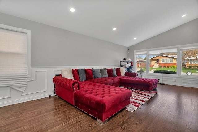 living room with lofted ceiling, wainscoting, wood finished floors, and a decorative wall