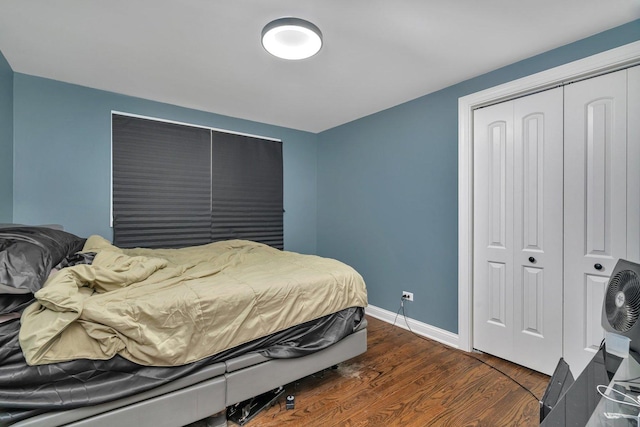 bedroom featuring dark wood finished floors, a closet, and baseboards
