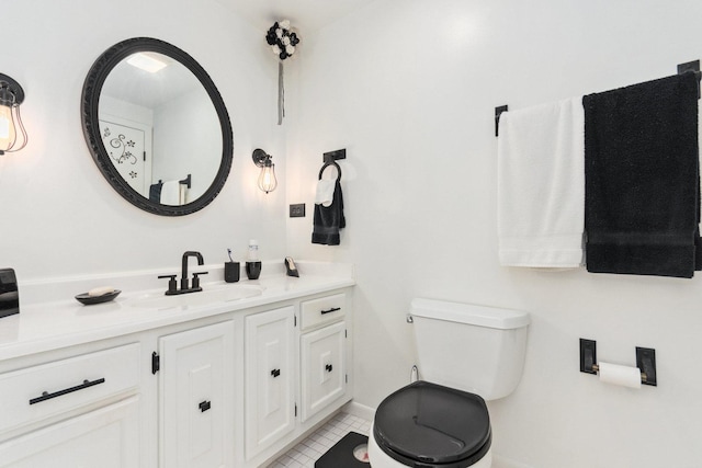 bathroom featuring toilet, tile patterned floors, vanity, and baseboards