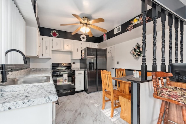 kitchen with stainless steel fridge with ice dispenser, a ceiling fan, marble finish floor, a sink, and black gas range oven