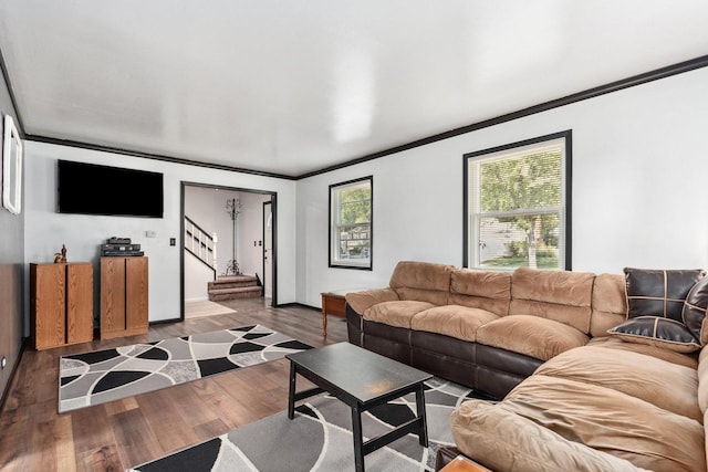 living room featuring stairway, baseboards, ornamental molding, and wood finished floors