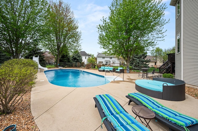 view of swimming pool featuring fence, a patio area, a fenced in pool, and a water slide