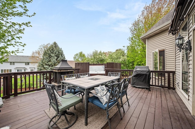 wooden deck with outdoor dining area and a grill