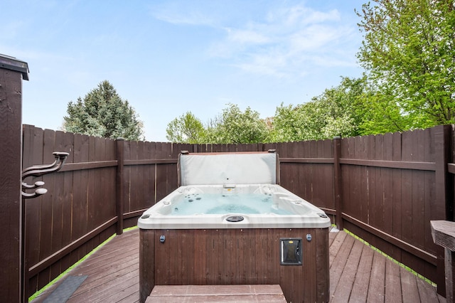 deck featuring a hot tub and fence