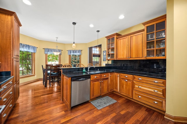 kitchen with stainless steel dishwasher, brown cabinetry, a sink, a peninsula, and dark wood-type flooring