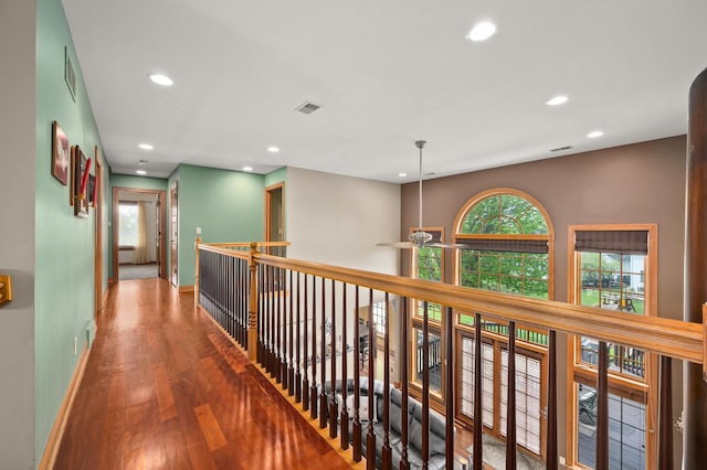corridor with baseboards, visible vents, recessed lighting, and wood finished floors