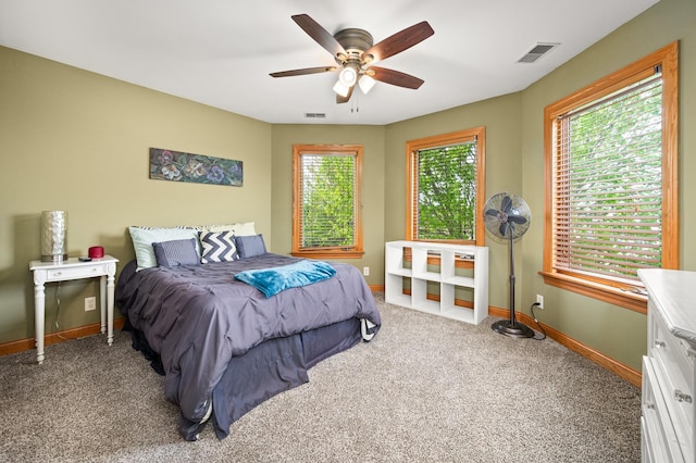 carpeted bedroom with ceiling fan, baseboards, and visible vents