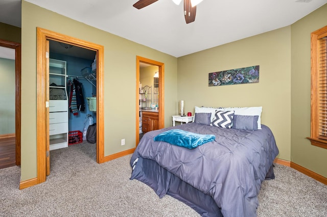 bedroom with a closet, ensuite bathroom, a walk in closet, and carpet floors