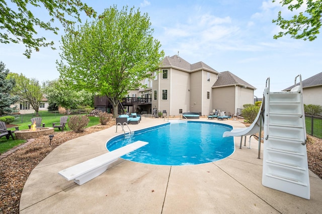 view of swimming pool with a deck, a patio, a diving board, and a water slide